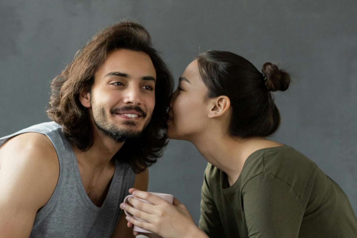 donna che parla all'orecchio ad un uomo 