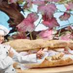 chef donna che indica un saltimbocca di pizza farcito
